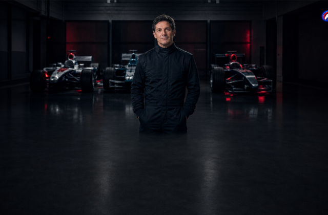 Giancarlo Fisichella dans un garage fictif devant trois monoplaces génériques — visuel éditorial généré par IA